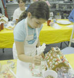 Applying frosting to her gingerbread house